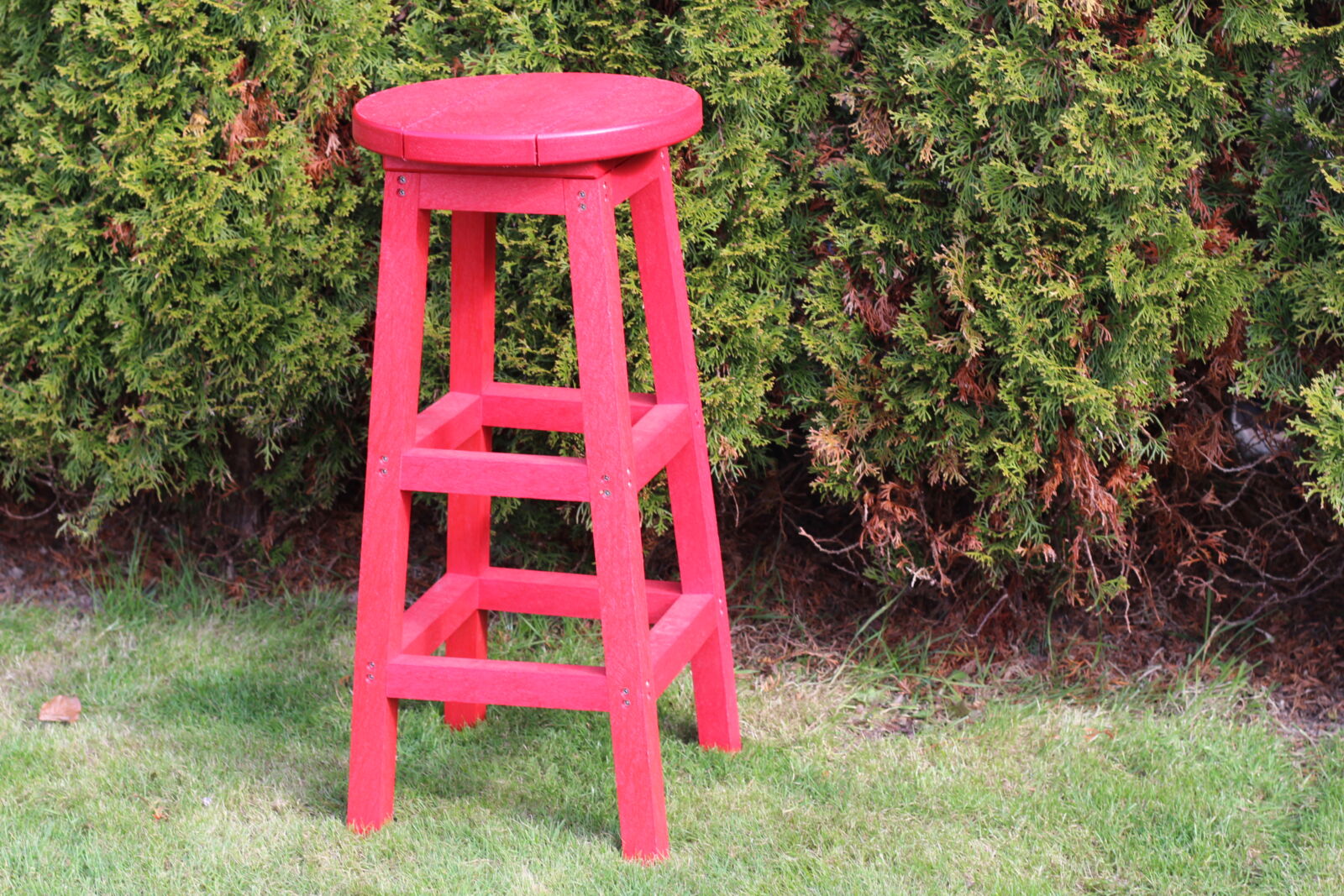 Red recycled plastic bar stool with hedge background | Mobek
