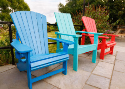 Group of teal, red and blue Adirondack chairs on paved patio – Mobek