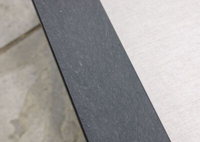 Close-up detail of dark grey recycled plastic outdoor furniture arm surface | Mobek