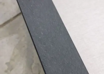 Close-up detail of dark grey recycled plastic outdoor furniture arm surface | Mobek