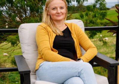 Woman in yellow cardigan sitting in grey recycled plastic deep-seat armchair with cream cushion | Mobek