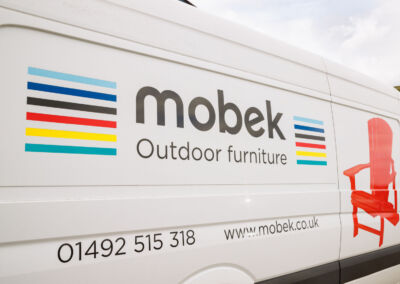 Mobek outdoor furniture delivery van showing phone number and website | Mobek